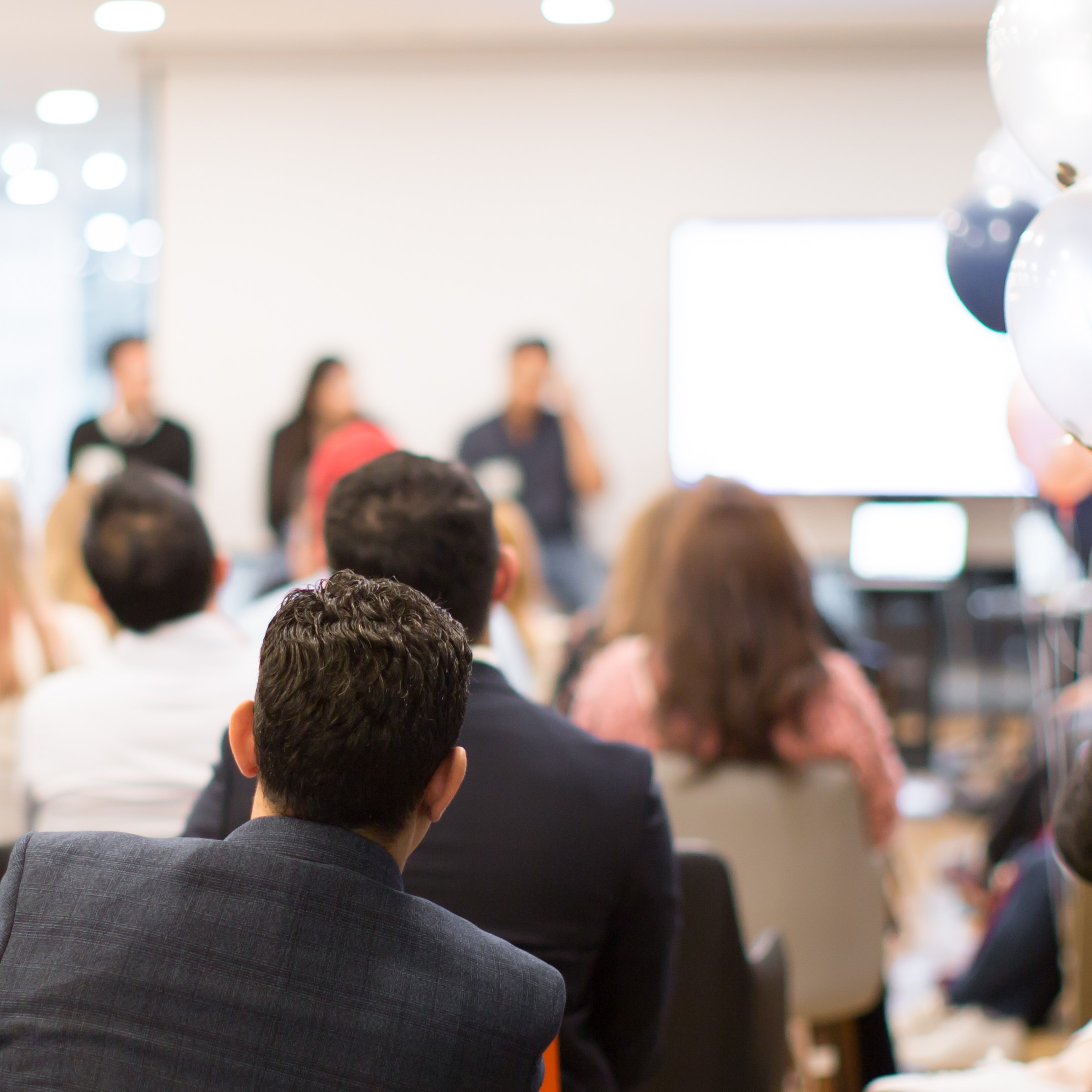 Stock image of people watching a presentation