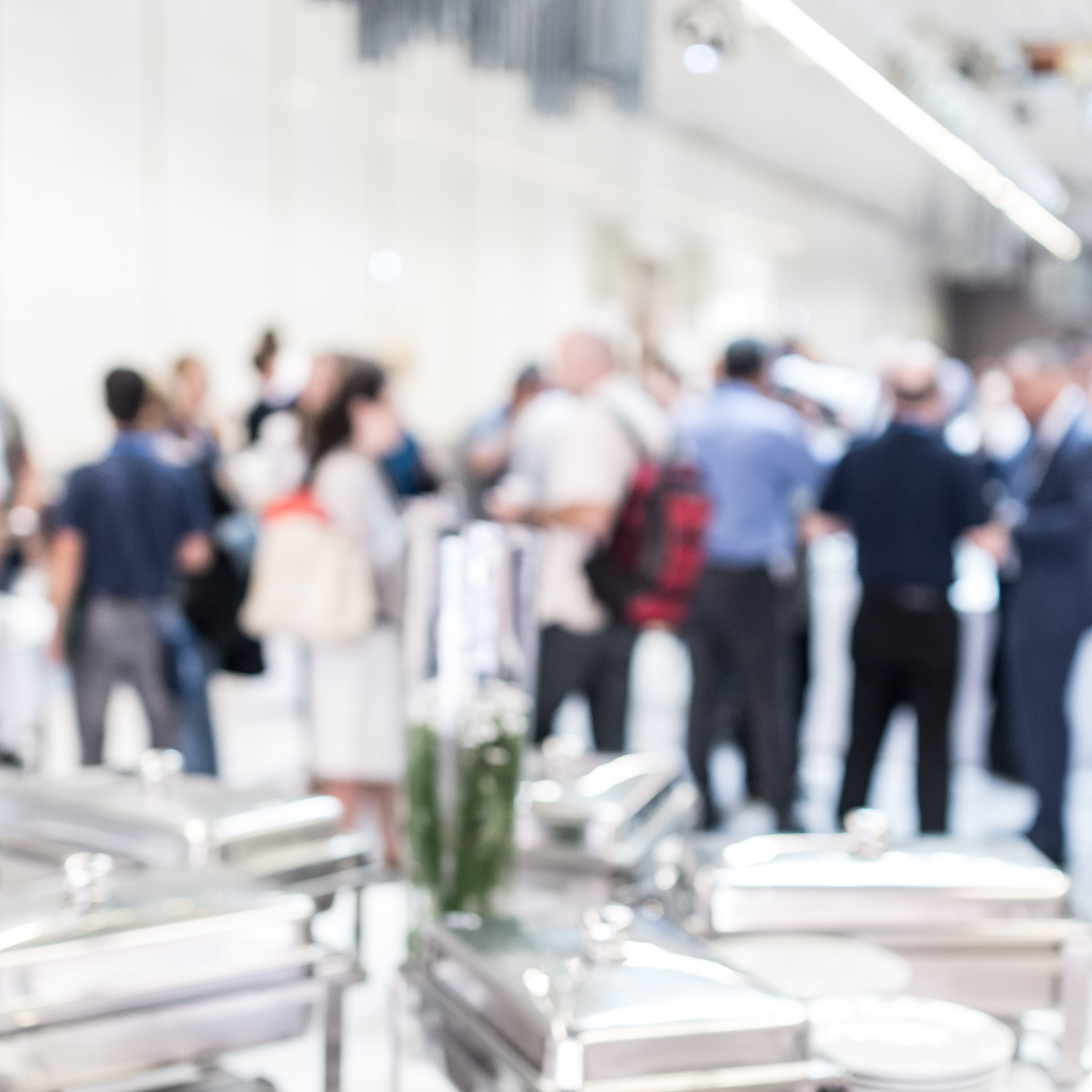 Image of reception table in the foreground with blurry image of people attending a reception in the background